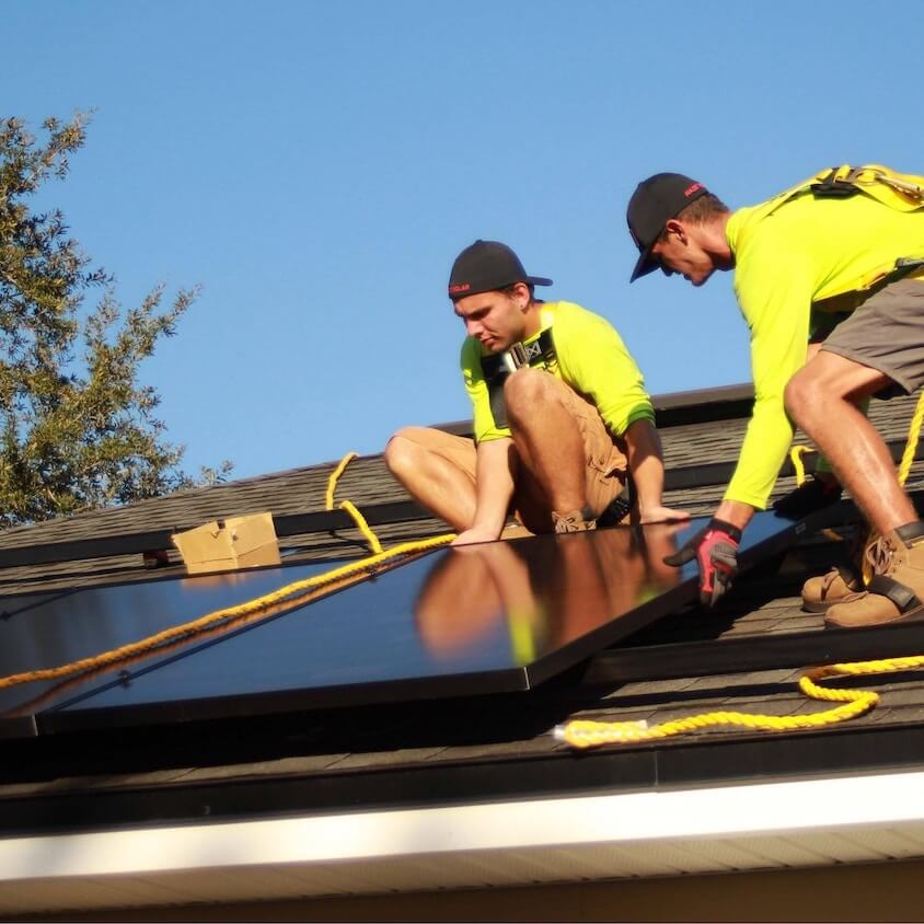 installateur un toit qui installe des panneaux solaires